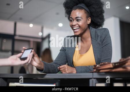 Receptionist handing business smartphone à la réception du bureau Banque D'Images