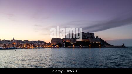 En silhouette sur la mer et Calvi au crépuscule, Corse, France Banque D'Images
