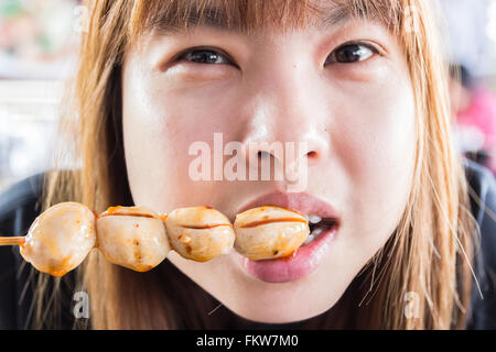 Asia girl eating meat balls Banque D'Images