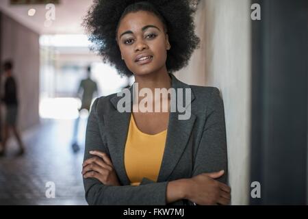 Portrait of young businesswomen leaning against wall bureau Banque D'Images