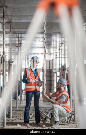 Les constructeurs mâle et femelle avec mètre construction de mesure Banque D'Images