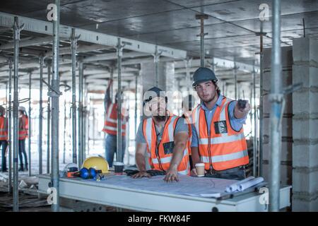 Chef de chantier et le constructeur qui pointe de plan en construction site Banque D'Images