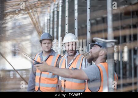 Gestionnaire de site et les constructeurs en pointant sur des tiges d'acier on construction site Banque D'Images