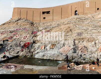 Lavage de tapis traditionnel à l'Cheshmeh Ali printemps à Rayy dans le sud de Téhéran. Époque qajare citadelle & Tapis de séchage au-dessus Banque D'Images