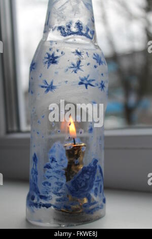 Bouteille de verre fragile avec photo de l'hiver Pays de nuit avec des brûler bougie à l'intérieur Banque D'Images