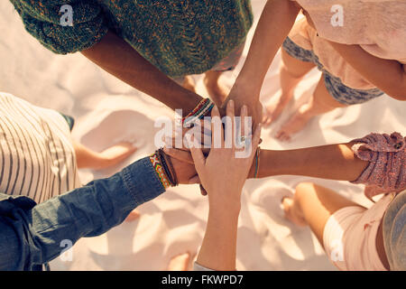 Groupe de jeunes hommes et femmes montrant l'unité. Groupe de jeunes amis mettent leurs mains à la plage. Banque D'Images