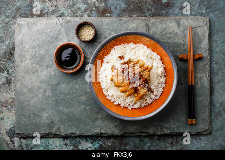 Sur le riz avec la sauce d'anguille et sésame sur fond ardoise Banque D'Images