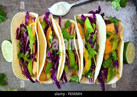 Tacos au poisson épicé avec du choux rouge Salade d'avocat et citron vert, vue aérienne sur le plateau rustique Banque D'Images