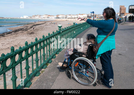 Quatre-vingt-dix ans, femme âgée et sa garde ou assistant à la recherche à la plage de Margate, promenade. Parution du modèle. Banque D'Images