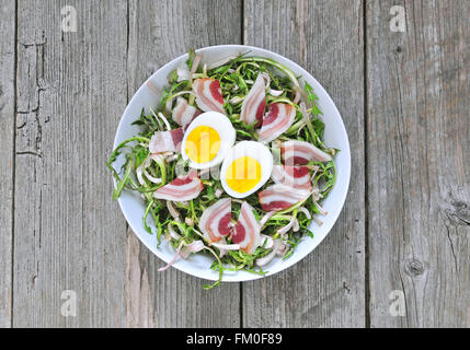 Salade de pissenlit frais avec des œufs durs et du bacon Banque D'Images