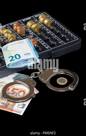 Menottes, l'introduction des billets et des pièces en euros d'un organisateur sur fond noir Banque D'Images
