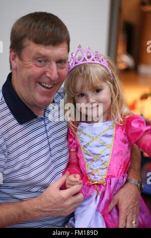 Petite fille, enfant vêtu d'un costume princesse portant une couronne hugging her grand-père Grand-parent concept, famille amour, parents, l'enfance de la joie Banque D'Images