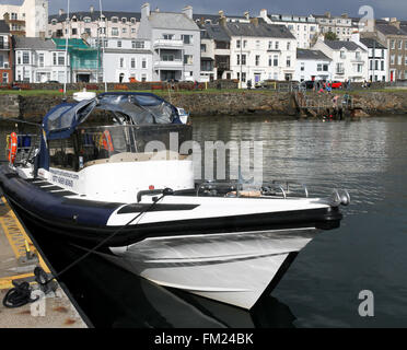 Portrush Seatours Rigid Inflatable Boat amarré dans le port de Portrush, comté d'Antrim, en Irlande du Nord avec les bâtiments du front de mer le long d'une journée d'été. Banque D'Images