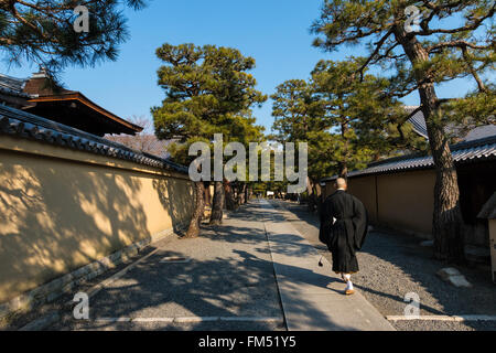 Un moine marchant dans un sentier entre des murs dans le temple Daitoku-ji temple bouddhiste Zen à Kyoto Banque D'Images