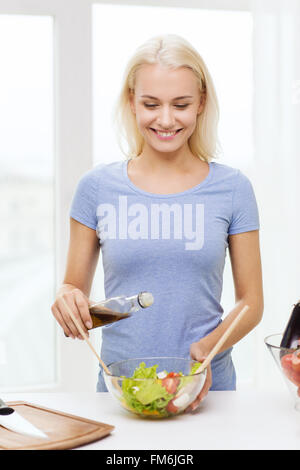 Smiling woman la cuisson de légumes grillés à la maison Banque D'Images