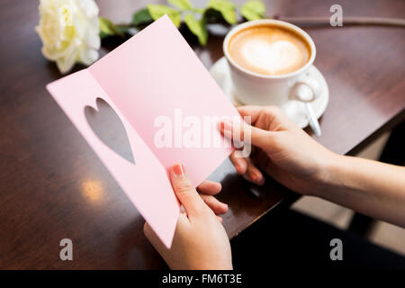 Lecture de carte de souhaits et de café Banque D'Images