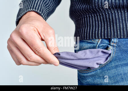 Un jeune homme de race blanche a éclaté en jeans montrant sa poche vide Banque D'Images