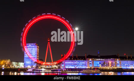 Londres de nuit - grande roue London Eye illuminée et sur les toits de la ville la nuit, la pleine lune qui brille derrière Banque D'Images