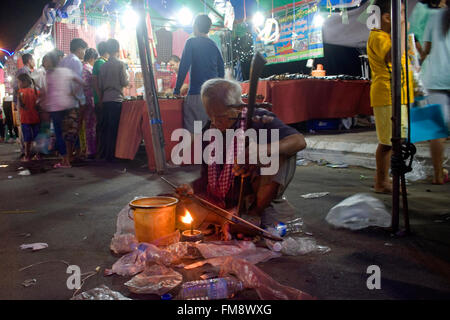 Un homme sans vision (aveugle) joue un instrument de musique traditionnel à une foire de rue dans la région de Kampong Cham, au Cambodge. Banque D'Images