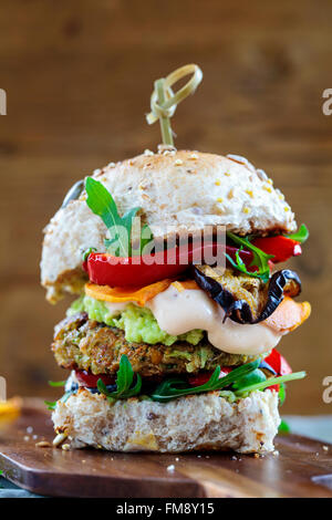 Burger végétarien fait de champignons, pois chiches et brocoli rôti avec du poivre, des aubergines, des feuilles de roquette et de l'avocat en purée Banque D'Images