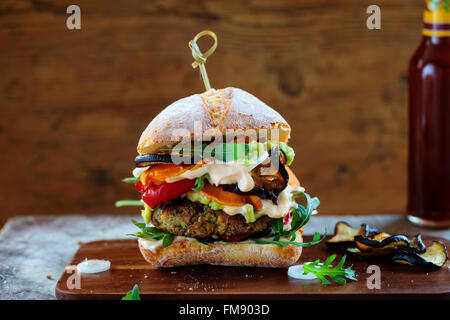 Burger végétarien fait de champignons, pois chiches et brocoli rôti avec du poivre, des aubergines, des feuilles de roquette et de l'avocat en purée Banque D'Images