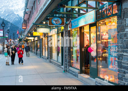 Boutiques dans l'Avenue Banff Banff Canada au crépuscule avec éclairage rougeoyant. Banque D'Images