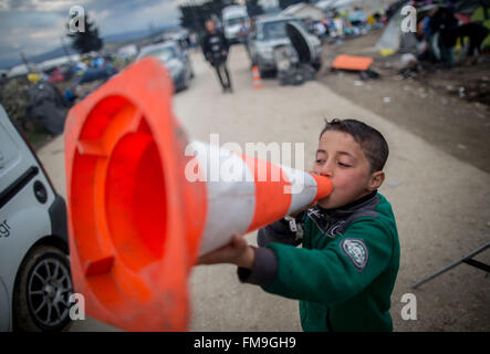 Idomeni, Grèce. Mar 11, 2016. Un jeune garçon réfugié jouant avec un cône dans le camp de réfugiés en Idomeni, Grèce, 11 mars 2016. Depuis la frontière a été fermée, 12 500 réfugiés vivent dans le camp. Photo : Kay Nietfeld/dpa/Alamy Live News Banque D'Images