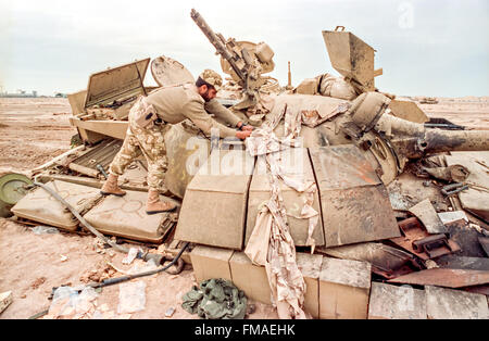 Un soldat Qatar examine un détruit le char de combat T-55 Irakiens au cours des opérations de nettoyage à la suite de la bataille de Khafji, le 2 février 1991 dans la ville de Khafji, l'Arabie Saoudite. La bataille de Khafji a été la première grande mobilisation de masse de la guerre du Golfe. Banque D'Images