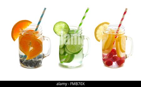 Trois types de fruits rempli de l'eau de désintoxication dans des pots Mason avec paille isolé sur fond blanc Banque D'Images
