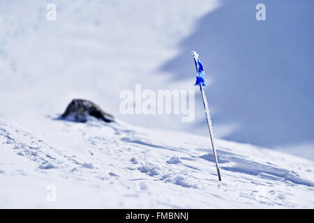 Drapeau bleu soufflé par le vent sur une montagne en hiver Banque D'Images