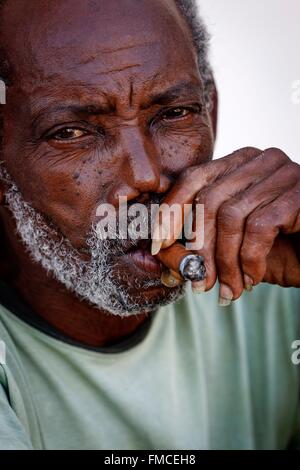 Cuba, Pinar del Rio, Vinales, Portrait d'un homme avec la peau noire fumer un cigare Banque D'Images