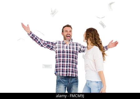 Happy young couple jeter billets de monnaie dans l'air Banque D'Images