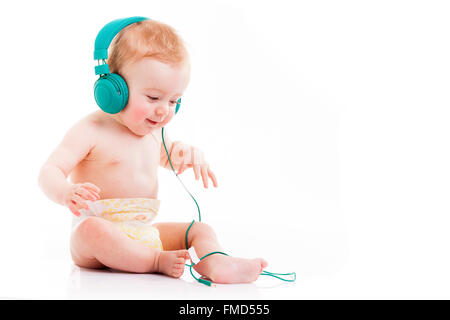 Happy Baby avec un casque à l'écoute de la musique sur fond blanc Banque D'Images