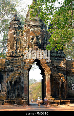Les cyclistes en passant par North Gate, Angkor Thom, Parc archéologique d'Angkor, Siem Reap, Cambodge Banque D'Images