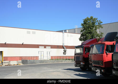 Les camions rouges sur fond d'un entrepôt blanc Banque D'Images