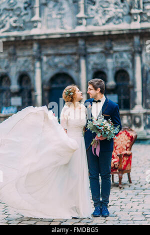 Gorgeous blonde mariée en dentelle longue robe de mariage et le marié élégant dans des verres un plaisir de regarder les uns les autres Banque D'Images