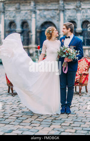 Happy happy wedding couple souriant joyeusement avec l'ancienne architecture baroque sur l'arrière-plan Banque D'Images