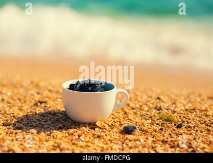 Boue de la mer morte pour les soins spa dans une tasse sur la plage Banque D'Images