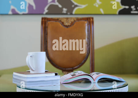 Réserver et tasse de café sur la table de la chambre de travail Banque D'Images