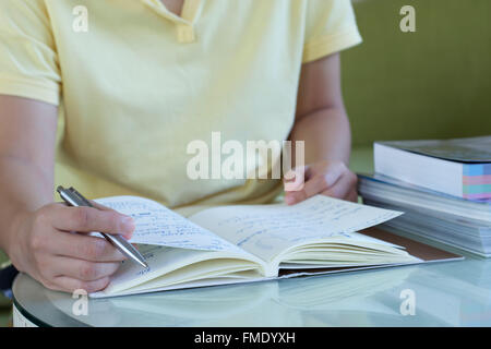 L'étude des femmes main tenant un stylo et la lecture d'un livre Banque D'Images