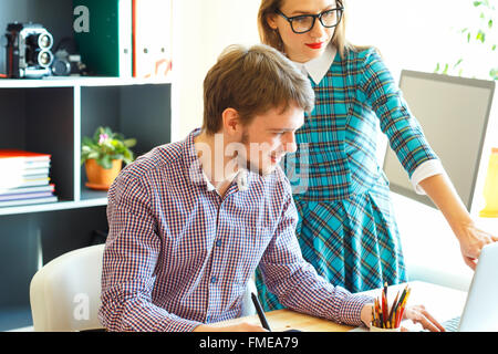 Belle jeune femme et l'homme travaillent à domicile - concept d'affaires moderne Banque D'Images