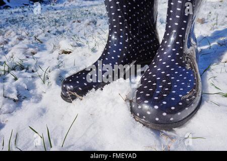 Bottes d'hiver noir avec pois blancs dans la neige de l'hiver Banque D'Images