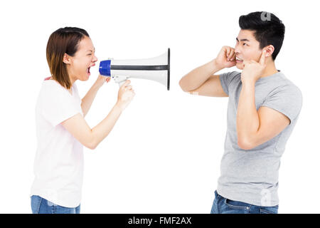 Femme en colère en criant au jeune homme sur haut-parleur à pavillon Banque D'Images