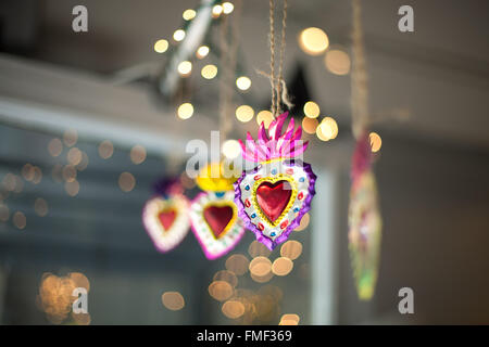 Décorations sacré-cœur accroché dans une fenêtre avec twinkle lights derrière eux. Banque D'Images