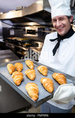 Portrait d'un chef holding tray of croissants Banque D'Images