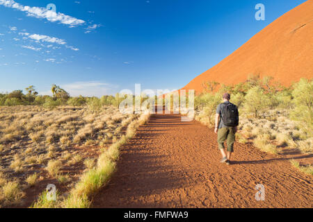 Homme randonnée à Uluru (Site du patrimoine mondial de l'UNESCO), Parc National d'Uluru-Kata Tjuta, Territoire du Nord, Australie (MR) Banque D'Images