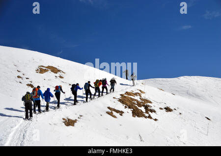 Groupe de personnes la raquette à neige dans les Dolomites italiennes Banque D'Images