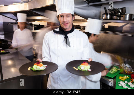 Happy chef présentant ses plaques alimentaire Banque D'Images