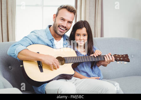 Portrait d'heureux père jouer de la guitare avec fille Banque D'Images