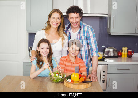 Portrait of smiling family préparer une salade de légumes Banque D'Images